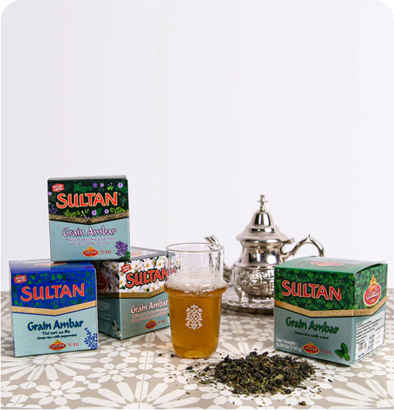 Sultan Tea boxes with a glass cup filled with tea and a traditional teapot on a patterned table